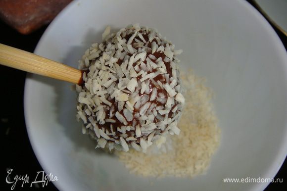 Обмакиваем кейк-попсы в кокосовую стружку и устанавливаем их, например, в дуршлаг, посуду с сахаром, можно взять коробку и сделать в ней дырочки для палочек и вставлять в них готовые кейк-попсы.