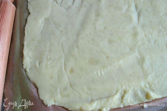 Остывший картофель разместить на бумагу для выпечки, придать ему прямоугольную форму, накрыть бумагой для выпечки, слегка прокатать скалкой. Снять верхний слой бумаги.