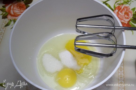 В чашу разбиваем куриные яйца. Добавляем соль и сахар. Взбиваем миксером.
