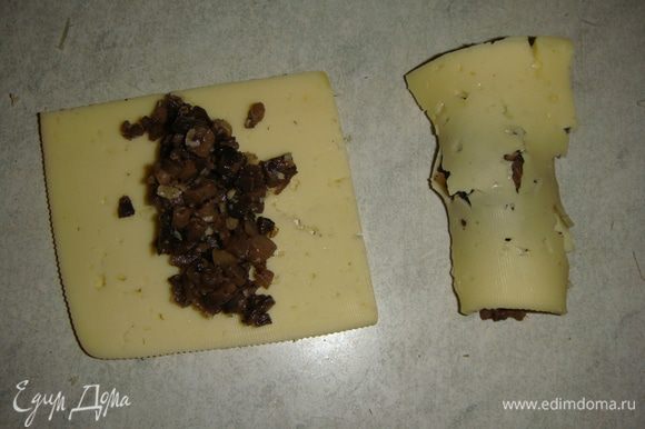 На кусочек сыра выкладываем грибы и сворачиваем в рулетик. Можно сыр нарезать брусочками. Я делала и так, и так, вкус от этого не меняется.