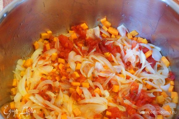 Добавим в кастрюлю морковь и помидоры. Обжарим на среднем огне, помешивая, несколько минут (пока будем нарезать капусту).