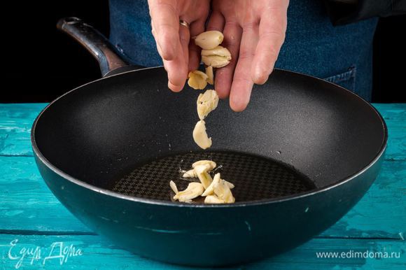 Разогреть оливковое масло на сковороде. Добавить чеснок, раздавленный плоской стороной ножа. Слегка поджарить до появления аромата.
