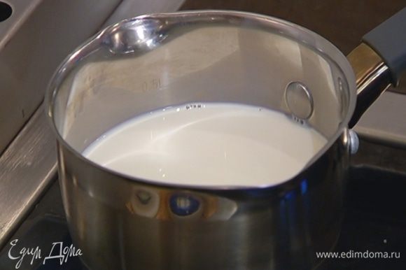 Молоко влить в кастрюлю, добавить 100 мл воды, сахар и нагреть на маленьком огне примерно до 40°С.