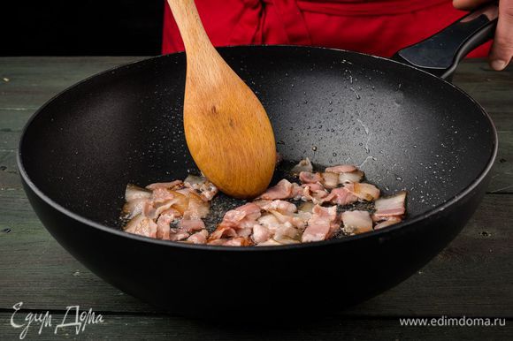 Разогреть в сковороде-вок 1 ч. ложку оливкового масла, обжарить бекон, затем выложить его на бумажное полотенце, чтобы удалить излишки жира.