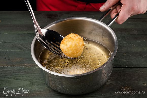 Разогреть в сотейнике оливковое масло и обжаривать шарики со всех сторон до появления золотистой корочки, а затем выкладывать на бумажное полотенце, чтобы убрать излишки жира.