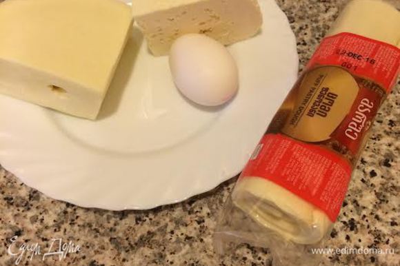 Духовку нагреть до 190°С. Готовое слоеное тесто достать из холодильника и дать полежать 15-20 минут. Сыр натереть на крупной терке.