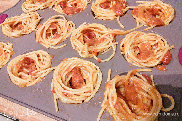 Формочки для маффинов смазать маслом (у меня силиконовая, поэтому я это упустила). С помощью вилки, наматывая на нее спагетти, выложить гнезда со свободной серединкой. Спагетти хватило ровно на 12 формочек.
