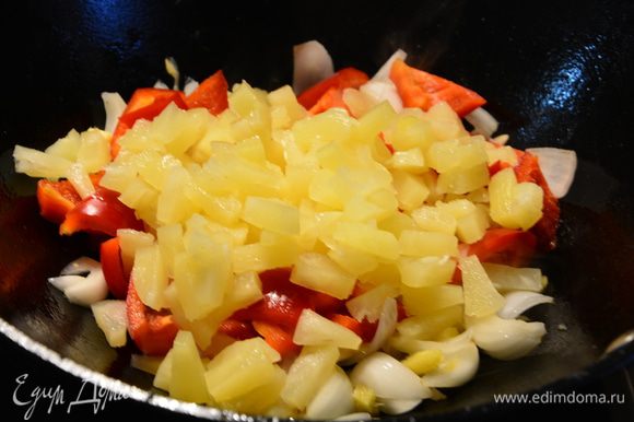 Добавить болгарский перец, кусочки консервированных ананасов. Перемешать и жарить 1-2 минуты.