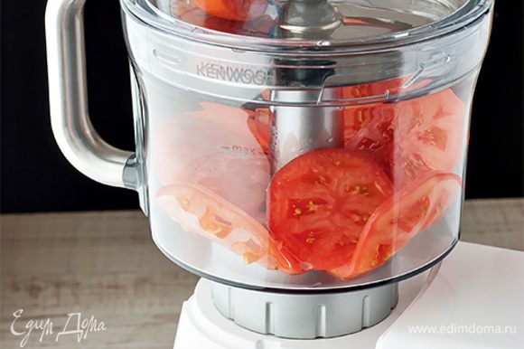Нарежьте помидоры толстыми кружочками. Важно, чтобы они получились одинакового размера. Вы можете воспользоваться обычным ножом или же доверить эту работу насадке кухонный комбайн. С ее помощью вы получите идеально ровные и одинаковые кружочки помидора.