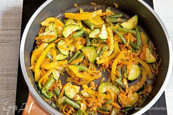 Разогрейте в глубокой сковороде 3 ст. л. оливкового масла и обжарьте на нем лук и чеснок до золотистого цвета. Добавьте в сковороду натертые овощи к луку с чесноком. Киньте туда же перец чили, тимьян, щепотку сушеных трав. Выложите фузилли в сковороду к овощам, перемешайте и снимите с огня.