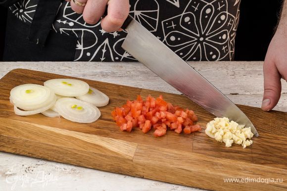 Репчатый лук нарезать тонкими кольцами, помидор нарезать небольшими кубиками, чеснок порубить.