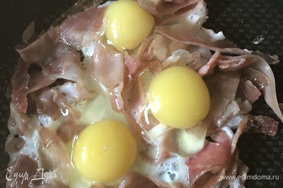Когда хамон станет хрустящим, влейте яйца и жарьте пару минут, пока белки не потеряют прозрачность. Всыпьте в центр сыр и дайте ему слегка расплавится. Посыпьте тимьяном и свежемолотым черным перцем.
