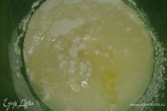 Влить теплую сыворотку и добавить яичный белок. Начать замешивать тесто ложкой. Затем влить подсолнечное масло и вымешивать тесто в течение 5-ти минут.