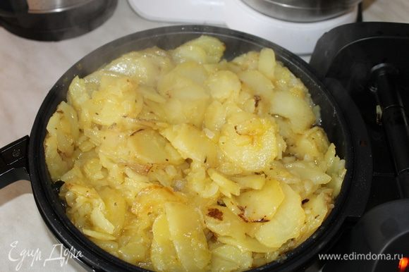 Картофель нарежьте тонкими слайсами, нашинкуйте лук и обжаривайте на оливковом масле до полной готовности.