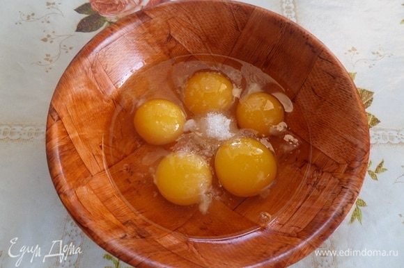 В чашку разбиваем куриные яйца. Добавляем соль и сахар.
