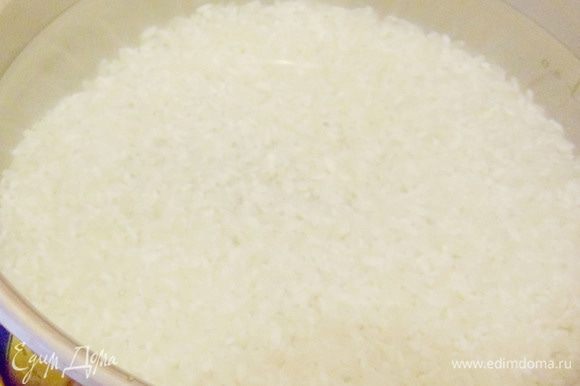 Рис промыть теплой водой дочиста, затем залить холодной водой, оставить выстаиваться на время около 2 часов. Затем воду слить. Залить рис 1,5 стаканами свежей холодной воды.