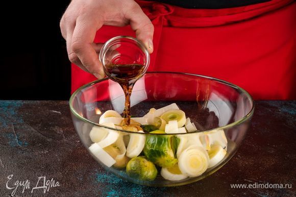 Смешайте капусту, лук, чеснок, оливковое масло, уксус. Посолите по вкусу. Выложите в форму для запекания. Запекайте в духовке 25 минут при 180°С.