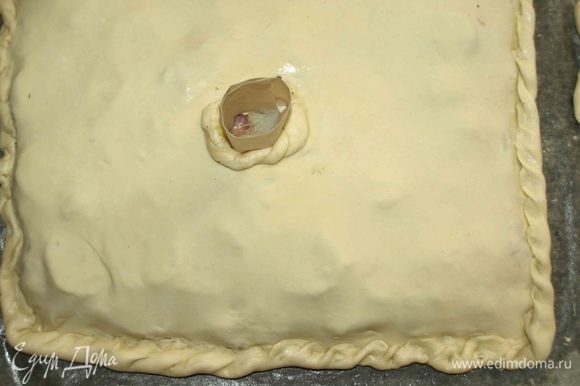 Меньшую часть раскатываем. Закрываем пирог. Хорошо соединить края. Делаем в центре пирога отверстие, добавляем 3 ложки воды. Оставьте небольшой кусочек теста, чтобы сделать украшение вокруг отверстия.
