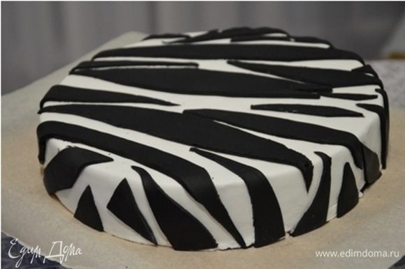 Ганаш застыл, можно покрывать мастикой. Этот вариант украшения очень простой: покрываем торт белой мастикой, а из черной вырезаем произвольные полосочки и выкладываем в произвольном порядке на торт.