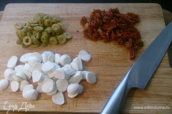 Нарезаем кольцами оливки, соломкой вяленые томаты, и мини-моцареллу просто пополам.