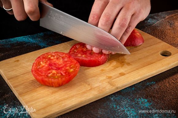 С помидора снять кожицу, нарезать его кусочками.