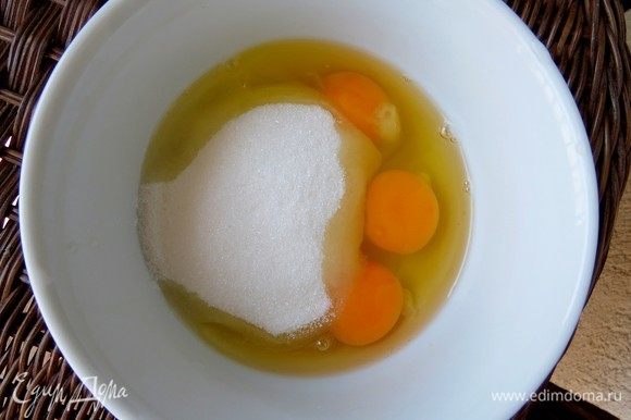 Готовим крем для смазывания листьев теста фило. В глубокую миску разбиваем 3 яйца, засыпаем сахар.