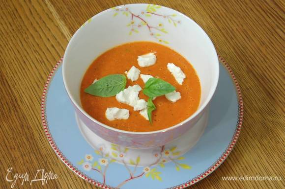 Разлить суп в тарелки, сверху разложить разломленный на кусочки козий сыр, украсить листьями базилика.