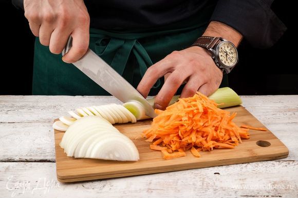 Нарежьте полукольцами репчатый лук и белую часть лука-порея, морковь очистите и натрите на терке.