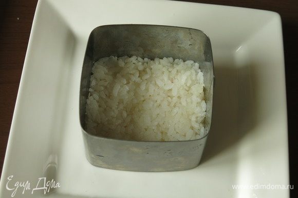 В квадратную форму (размер 8х8) утрамбовываем 55 г вареного заправленного риса, чуть смочив пальцы.
