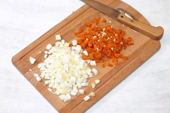 Очищенные и охлажденные морковь (небольшая) и вареные куриные яйца (2 шт.) нарезаем мелкими кубиками. Измельчаем очищенный зубчик чеснока и перемешиваем с морковью.