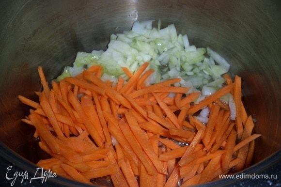 Ставим кастрюлю на огонь. Наливаем в кастрюлю растительное масло. Добавляем нарезанные лук и морковь.