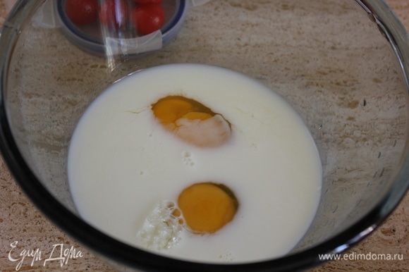 В стекляную миску влить молоко, вбить 2 яйца.