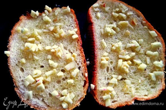 Хлеб смазать оливковым маслом и покрошить сверху нарубленный чеснок.