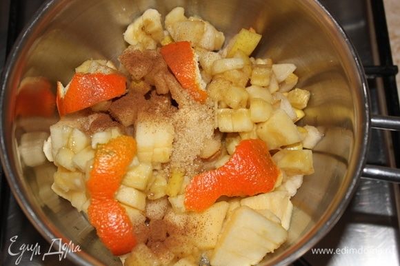 Сразу же всыпать нарезанные яблоко, грушу, банан, корицу, тросниковый сахар, 1/3 цедры мандарина. Накрыть крышкой, и оставить томиться на медленном огне, переодически помешивая.