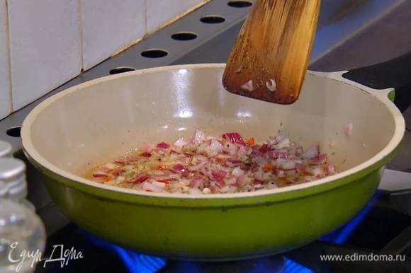 Разогреть в сковороде 2 ст. ложки оливкового масла, выложить лук, чили и чеснок, посыпать орегано, слегка посолить, поперчить и обжарить.