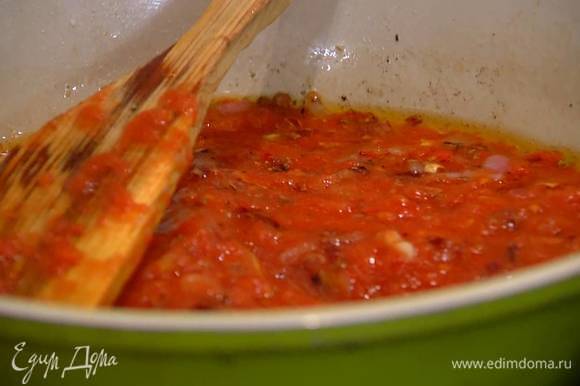 В сковороду с луком и чесноком добавить измельченные томаты, немного соли и сахар, все перемешать и прогреть на небольшом огне.