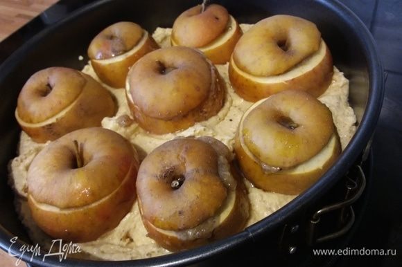 Разложить тесто по форме, выложить яблоки, вдавливая их слегка в тесто.