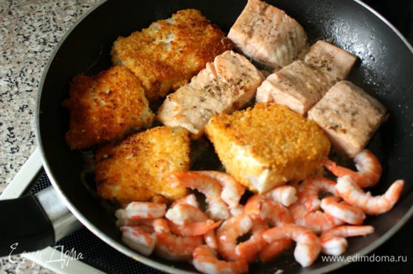 После того, как обжарится одна сторона, перевернуть рыбу и добавить в сковороду мелкие креветки и нарезанный красный лук, слегка обжарьте их, пока готовится рыба.