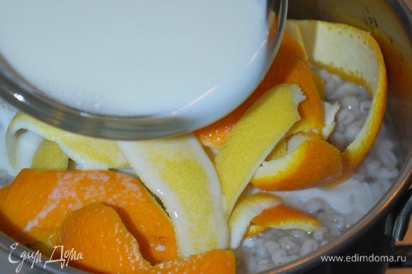 Добавим молоко и будем томить в течение 15-20 минут. Молоко пропитается ароматом цитрусовых и впитается в крупу. Все корки от апельсина и лимона уберем, крупа должна полностью остыть.