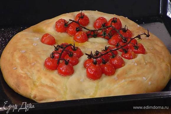Подошедшее тесто с помидорами сбрызнуть оставшимся оливковым маслом, посыпать крупной солью и выпекать в разогретой духовке 20‒25 минут.
