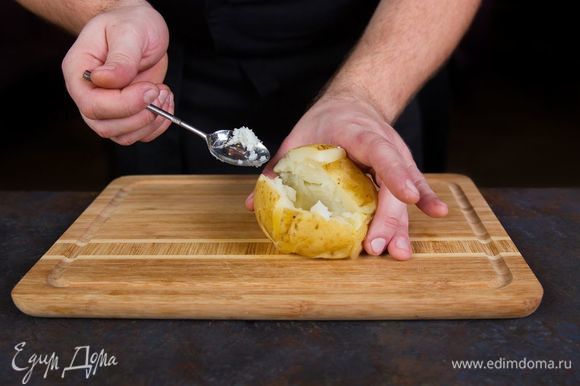Разрежьте готовый картофель в длину на две половины. Частично выньте мякоть с помощью чайной ложки.