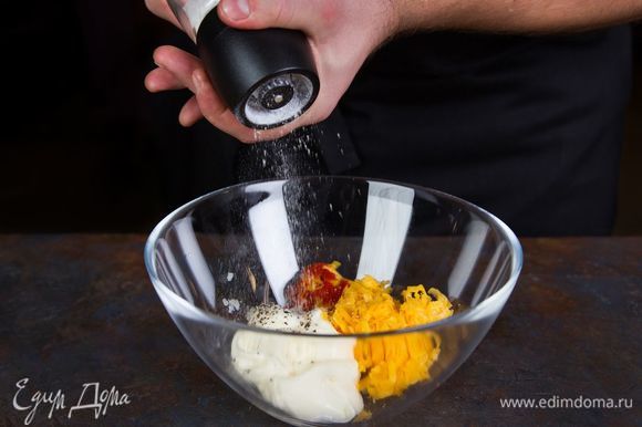 Бекон нарежьте мелко, соедините в миске с картофельной мякотью, частью тертого сыра, сметаной и специями. Все хорошо перемешайте.