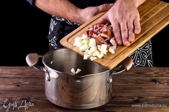 В кастрюле с толстым дном или глубоком сотейнике поджарьте на оливковом масле лук и мясо в течение 5 минут.