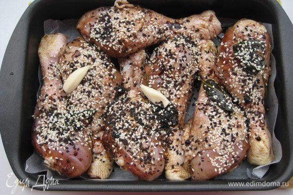 Переложить куриные голени вместе с маринадом в форму для запекания, посыпать кунжутом. Запекать при температуре 180°С до румяного цвета и готовности мяса (около 45 минут).