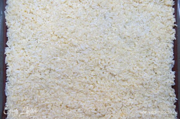 Рисовую массу выкладываем на противень, застеленный бумагой для выпечки или силиконовым ковриком. Бумагу или коврик предварительно немного смазать растительным маслом. Равномерно распределяем рисовую массу. Толщина слоя составляет примерно 5–7 мм.