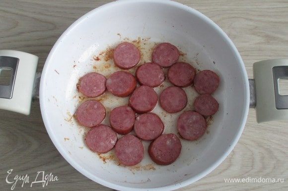 После ребер обжарьте кусочки колбасы и тоже уберите их на время.