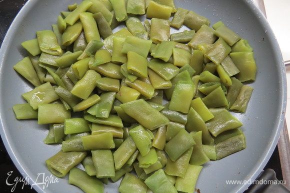 Зеленую фасоль обжарить на сковороде на оливковом масле, добавить чеснок. Вареную морковь нарезать кубиками.