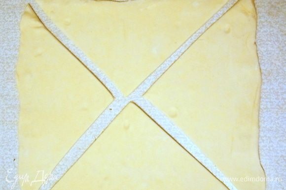 Слоеное тесто разморозить и раскатать не очень сильно. Разрезать по диагонали на четыре треугольника.