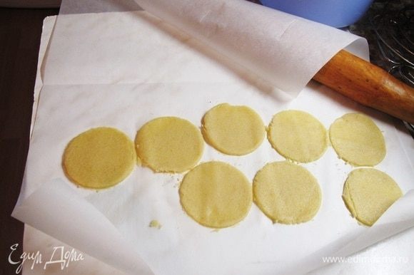 Раскатать тесто между двумя листами для выпечки до толщины 2–3 мм. Вырезать кружочки, равные диаметру пирожных, около 5 см. Положить в морозилку вместе с листами.