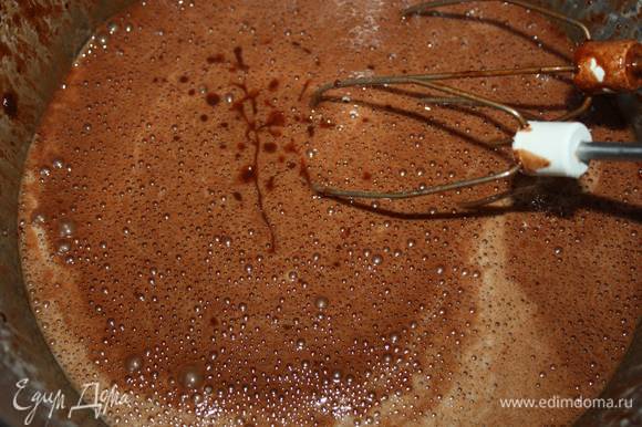 Затем нужно снизить скорость и тонкой струйкой влить в яичную смесь остывшую шоколадную массу.